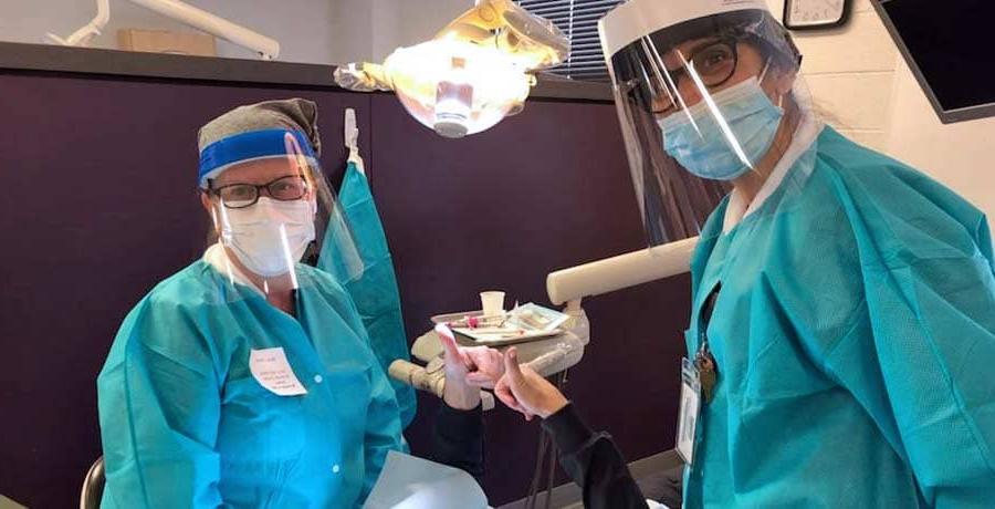 一名布法罗大学牙科卫生系的学生正在治疗一位病人
